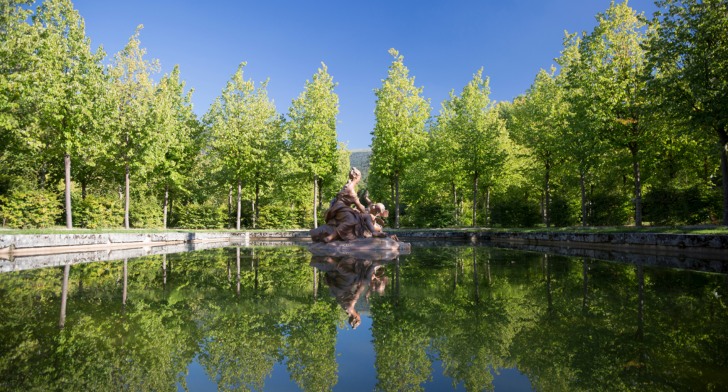 Escultura clásica reflejada en uno de los tranquilos estanques que forman parte de los jardines y fuentes de La Granja de San Ildefonso.