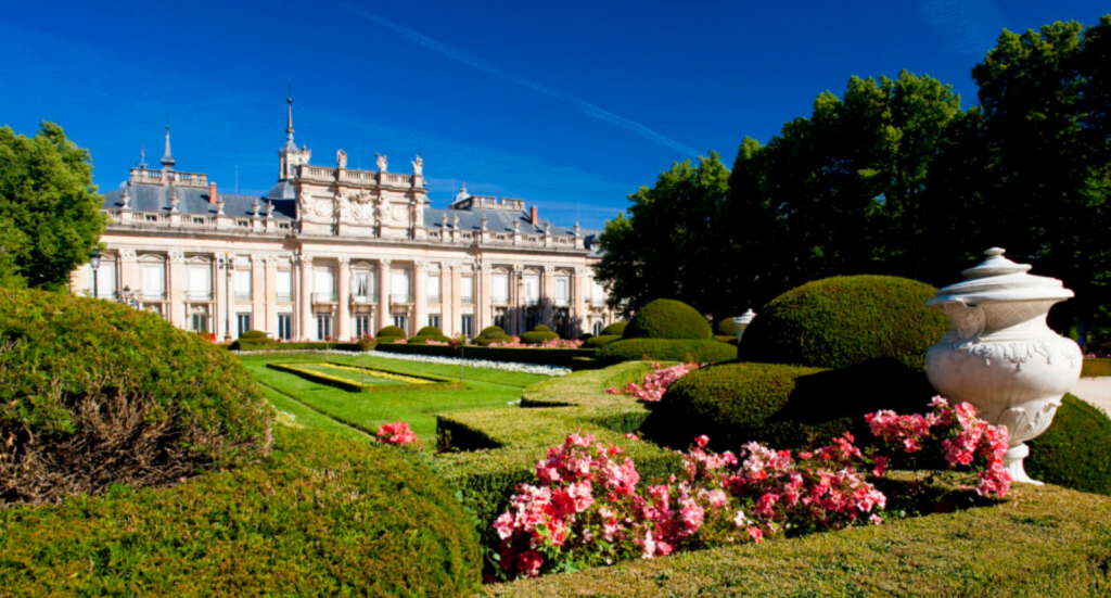 Fachada del Palacio Real y cuidados parterres de los jardines de La Granja de San Ildefonso, un destino clave para el turismo cultural en Segovia.